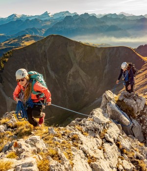 two climbers on a rocky grassy mountain