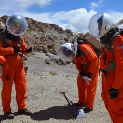 Three scientists in orange jumpsuits at Mars Desert Research Station