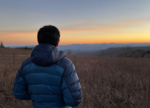 Elective student looking at sunset over hills